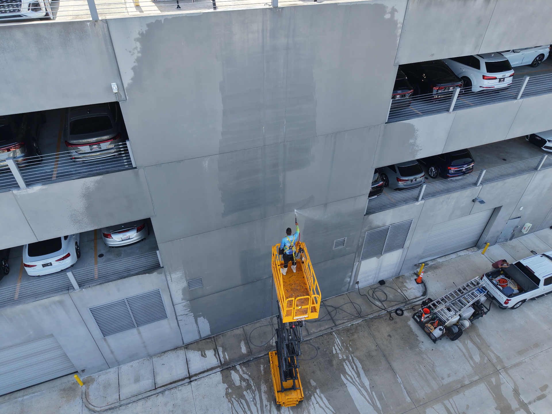 Aerial view of commercial building exterior pressure washing from lift in Hialeah FL