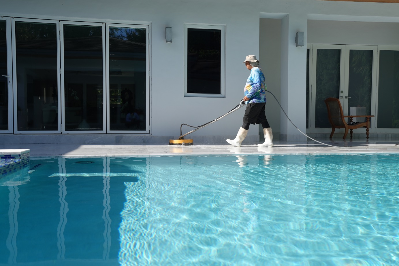 Worker cleaning pool deck with surface cleaner in Hialeah FL